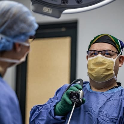 Dr Corné van Graan holding a flexible cystoscope in theatre